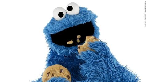 Cookie Monster Eating One Cookie While Holding Another Cookie In