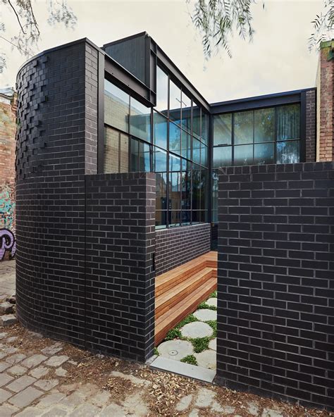 Black Brick Walls Wrap Around The New Addition To This Home