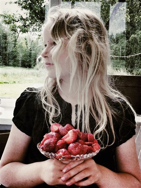 A Woman Holding A Bowl Full Of Strawberries