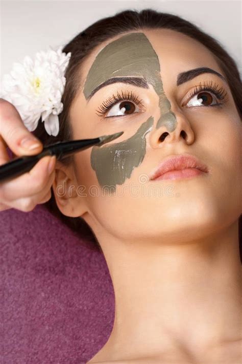 Spa Woman Applying Facial Clay Mask Beauty Treatments Close Up