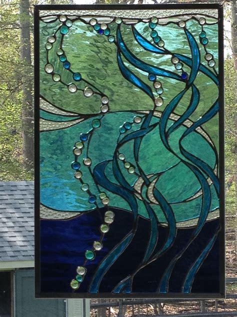 A Stained Glass Window With Blue And Green Waves