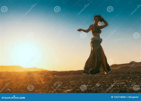 Woman Dancing To The Famous Arab Belly Dance With Sunset In The Arid