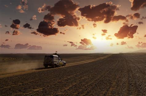 Free Photo Offroad Trail Car Speeding Through The Desert At Sunset