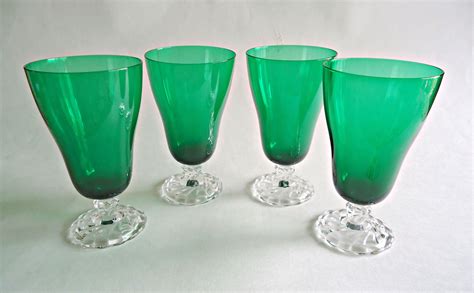 four green glass vases sitting next to each other