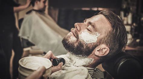 Client during beard shaving in barber shop - WDEKO