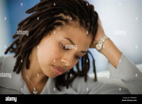 Serious Mid Adult Woman Leaning Her Head On Her Hand Stock Photo Alamy