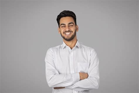 Smiling Handsome Young Arab Businessman With Folded Arms Standing Over