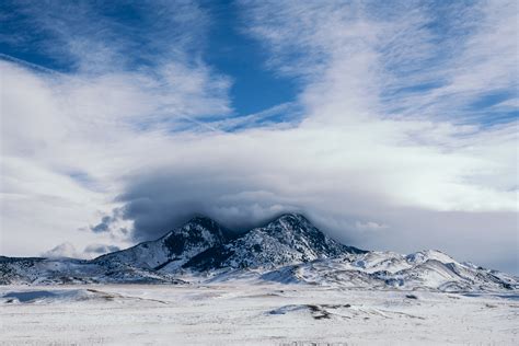 Photo Of Snow Capped Mountains Under Cloudy Sky · Free Stock Photo