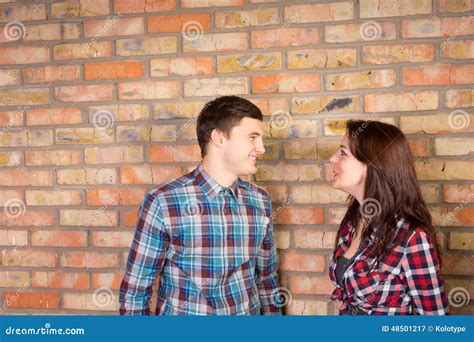 Smiling Couple Facing Each Other Near Brick Wall Stock Image Image Of