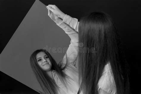 Young Woman Looking At Her Reflection In The Mirror Stock Photo Image