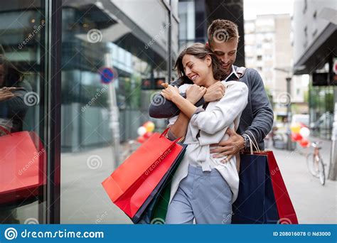 Beautiful Young Loving Couple Walking By The Street With Shopping Bags