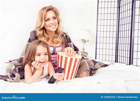 Excited Mom And Daughter Watching Tv And Eating Popcorn Stock Photo