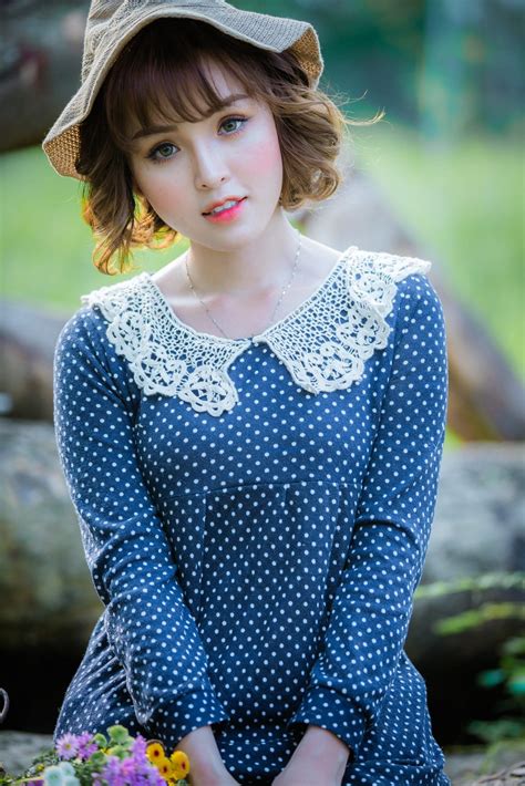 beautiful-asian-woman-wearing-a-blue-polka-dot-dress-in-the-woods-on