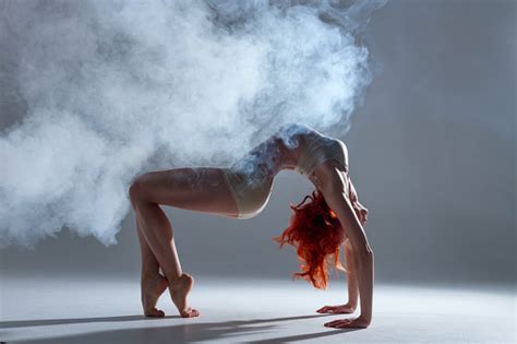 Muscle Redhead Woman Dancing In Smoke On Isolated Background Stock
