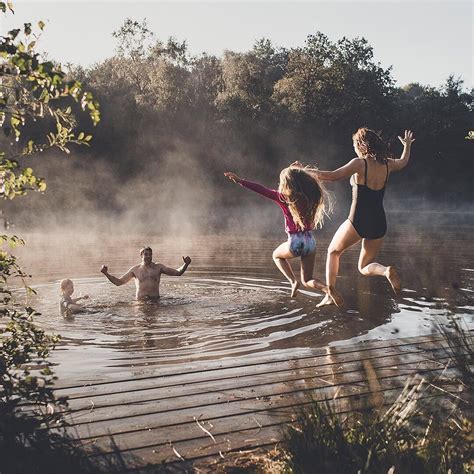 Three People Are Playing In The Water With Their Arms Out And One
