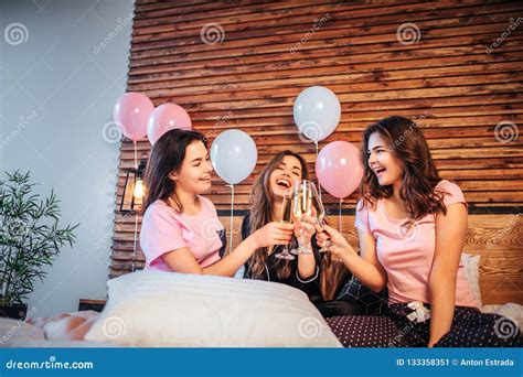 Three Young Women Have Pajama Party In Room On Bed They Sit Together