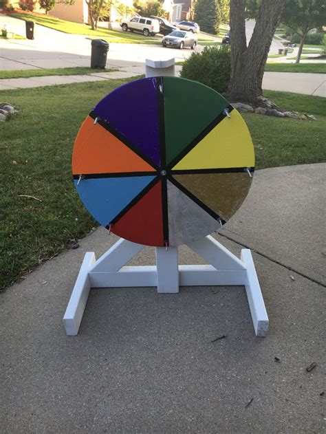 A Multicolored Wheel Sitting On Top Of A White Stand In The Middle Of A