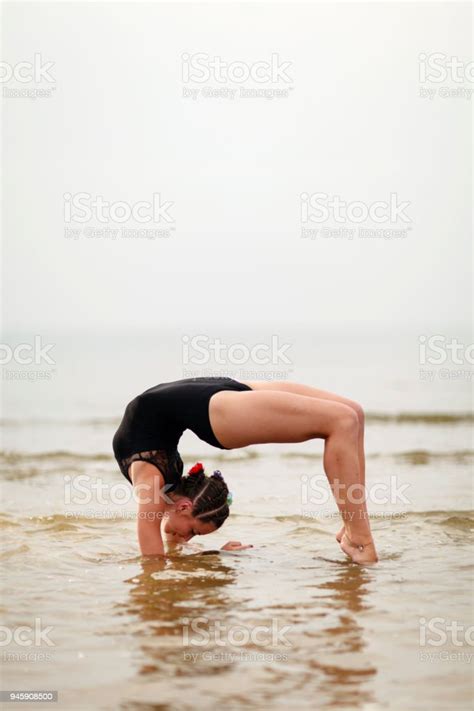 Young Beautiful Female Gymnast Training On Beach Stock Photo Download