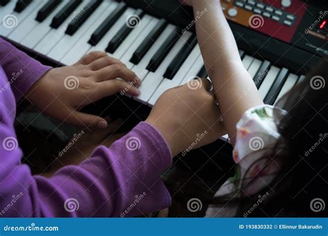 Hands Of Kid On Piano Keyboard Playing And Practising At Home Stock