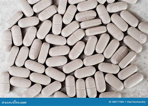 White Oblong Tablets In The Form Of Capsules On A Light Background