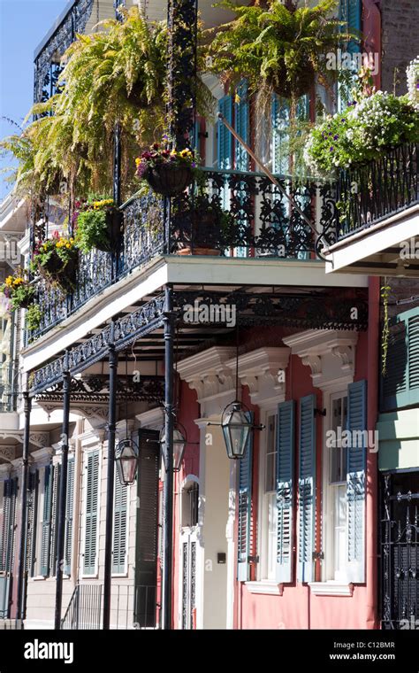 Creole Townhouse With Ornate Wrought Iron Balcony With Hanging Planters