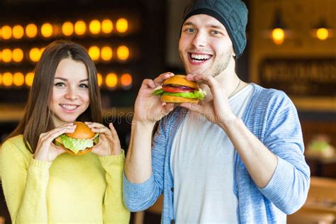 Homme Et Femme Mangeant L Hamburger La Jeune Fille Et Le Jeune Homme