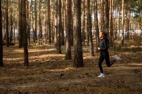 Young Athletic Woman Jogging In Forest In Sunny Morning Healthy