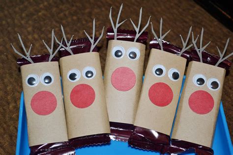 four brown paper bags with reindeer noses and nose on them, sitting in