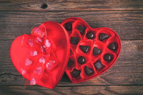 Chocolates In Red Heart Box On Rustic Wooden Table Stock Photo