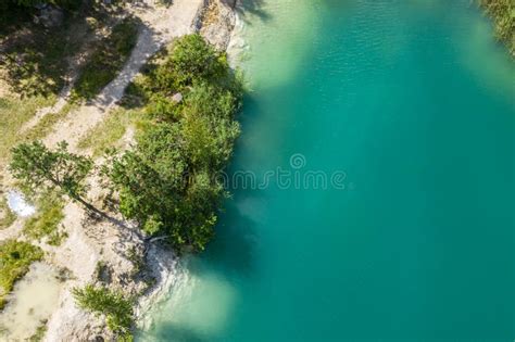 Aerial Top View Of Quarry Lake With Turquoise Water And Green Trees