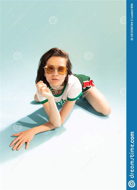 Portrait Of Beautiful Woman In Stylish Yellow Sunglasses Posing On Floor Isolated Over Light