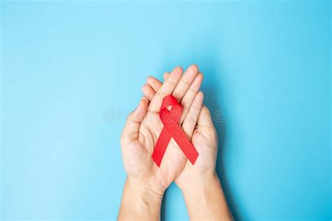 Man Holding Red Ribbon For Supporting People Living And Illness