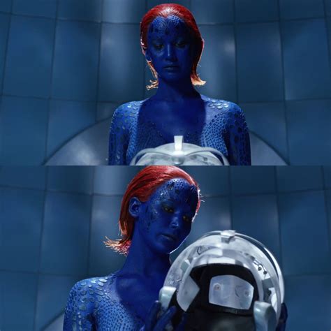 a woman with red hair and blue skin holding a helmet