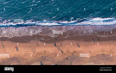 Aerial Looking Down View Of People Enjoying The Beach At Sunset In