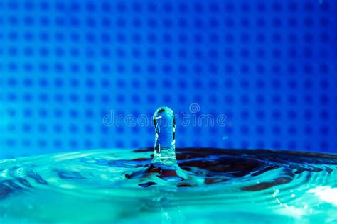 Drop Of Water Falling In Blue Water And Blue Background Stock Photo