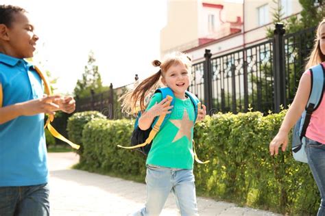Cute Little Children With Backpacks Running Outdoors Stock Photo