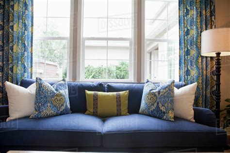 Close Up Of Cushions On Blue Couch Against Window In The Living Room At