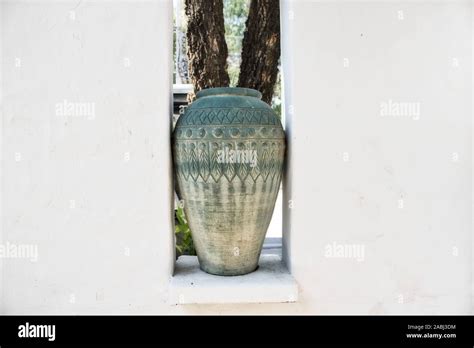 This Unique Photo Shows A Large Clay Vase In Green Standing Between A