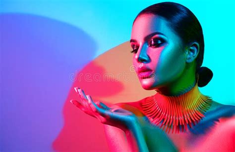 fashion model woman in colorful bright lights posing beautiful girl with trendy makeup stock