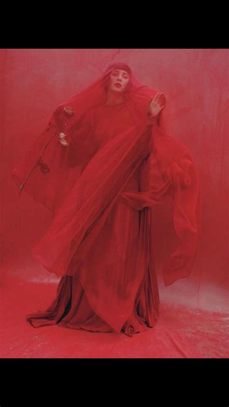A Woman In A Red Dress And Veil Poses For A Photo With Her Hands Behind