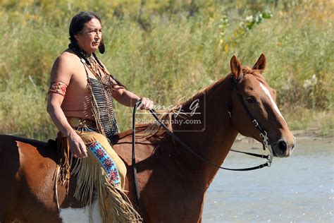 A Native American Indian Man Riding Bareback On A Horse Along A Rivers