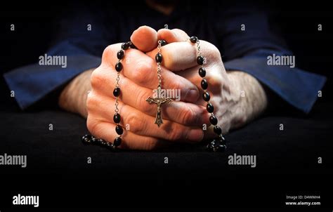 Hands Holding Rosary Beads And Cross While Praying Stock Photo Alamy