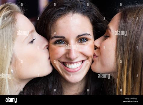 Portrait Of Cute Smiling Girl Kissed On The Cheeks By Her Friends Stock Photo Alamy