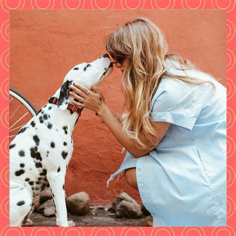 A Woman Is Petting A Dalmatian Dog On The Side Of A Building