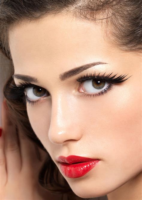 A Woman With Long Lashes And Red Lipstick On Her Face Is Posing For The Camera