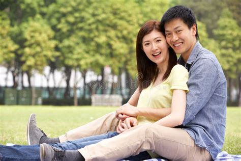 Young Chinese Couple Relaxing In Park Together Stock Photo Image Of