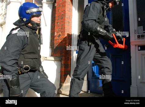 Police Officer About To Batter Down Front Door On Raid Of A Crack House