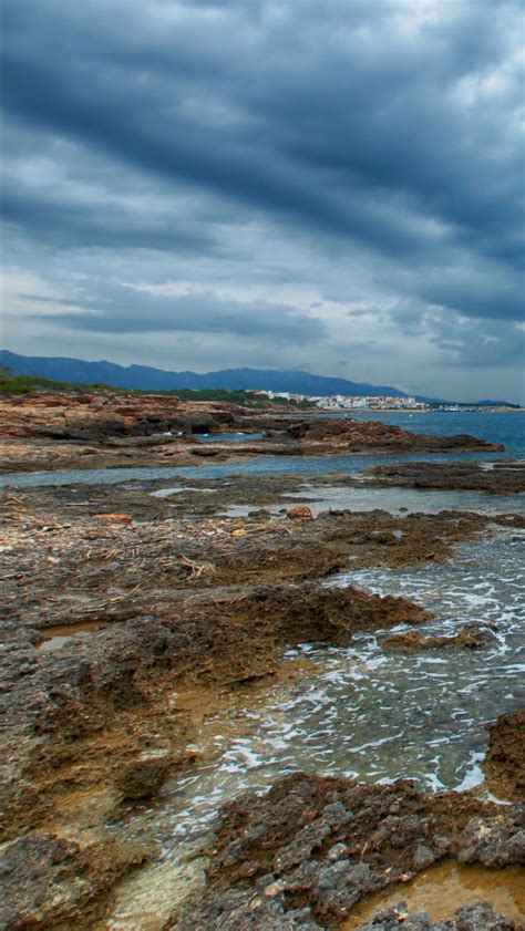 Sea Stones Ocean Waves Sand Landscape View Of Mountains Under Blue