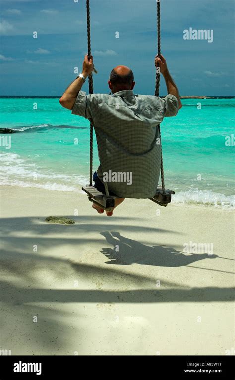 A Tourist Swings On A Beach Swing In The Maldives Stock Photo Alamy