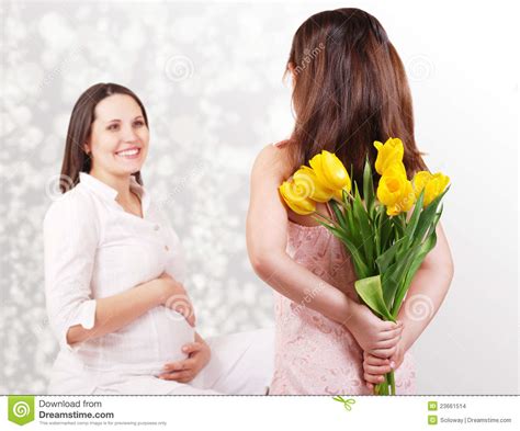 La Hija Tiene Flores Para Su Madre Embarazada Imagenes De Archivo